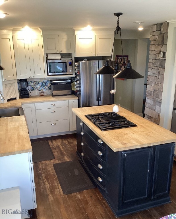 kitchen featuring appliances with stainless steel finishes, white cabinets, and pendant lighting