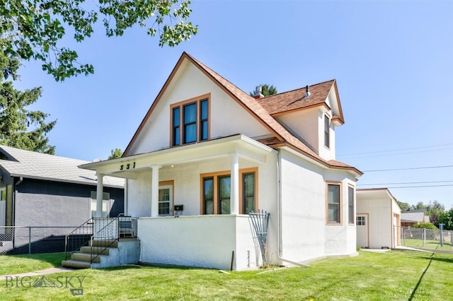 view of front of house with stucco siding, fence, a porch, and a front yard