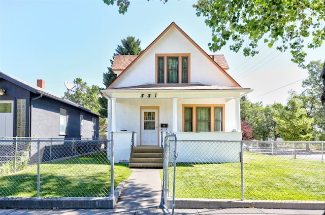 view of front facade featuring covered porch, a front lawn, a fenced front yard, and stucco siding