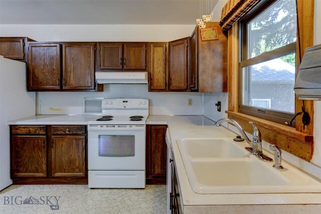 kitchen featuring sink, hanging light fixtures, and white appliances