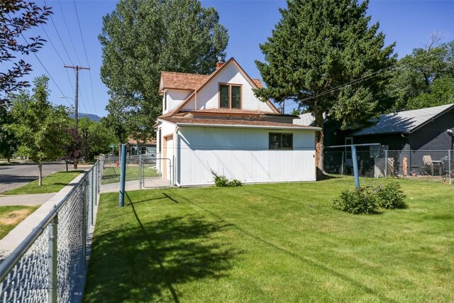 rear view of house featuring a lawn