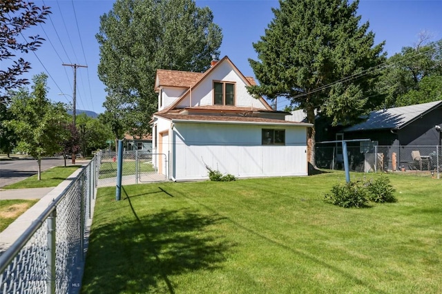 view of side of property with a lawn and fence