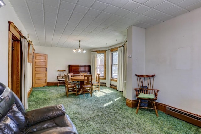 dining space featuring a notable chandelier, baseboards, baseboard heating, and carpet flooring