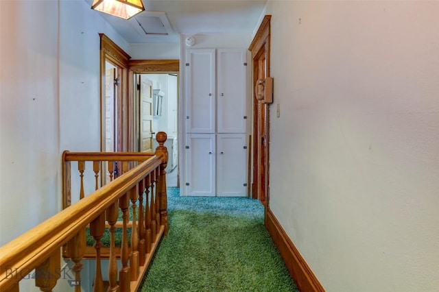 hallway featuring carpet floors, attic access, an upstairs landing, and baseboards