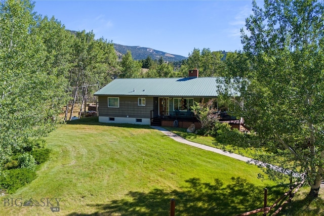 view of front facade featuring a deck with mountain view and a front lawn