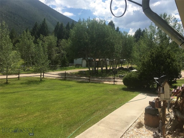 view of home's community with a lawn, fence, and a mountain view