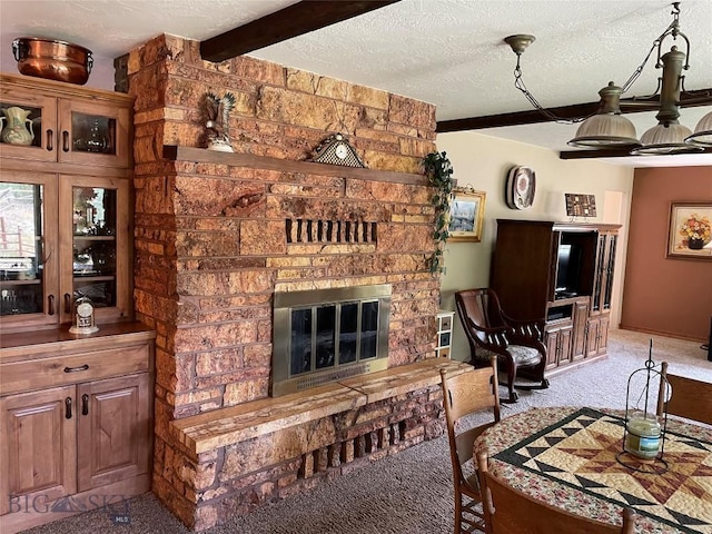 carpeted living room featuring a stone fireplace and a textured ceiling