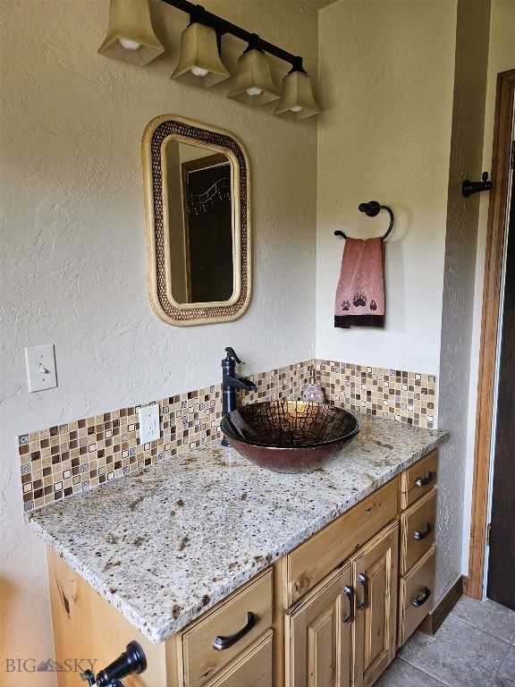 bathroom featuring backsplash, tile patterned floors, and vanity