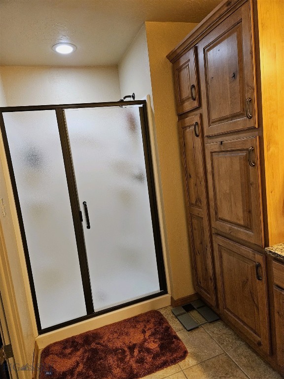 full bathroom featuring tile patterned floors, baseboards, a shower stall, and recessed lighting
