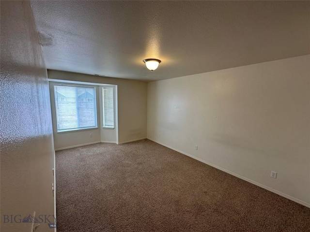 carpeted spare room with a textured ceiling