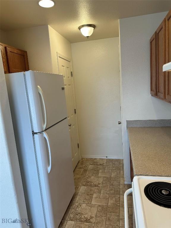 kitchen featuring white refrigerator and range with electric stovetop