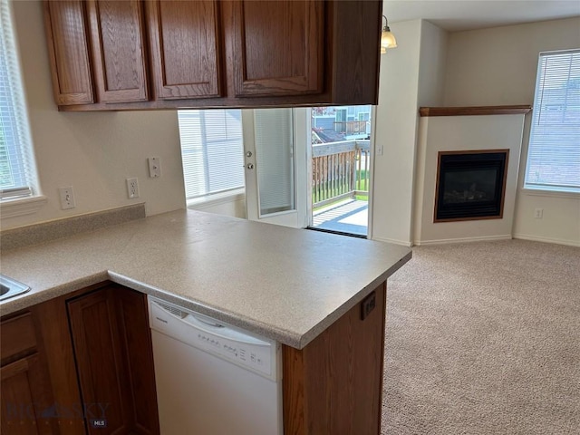 kitchen with light carpet, hanging light fixtures, kitchen peninsula, and dishwasher