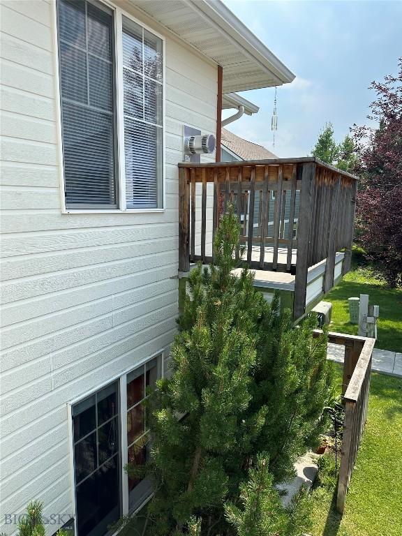 view of side of home with a lawn and a deck