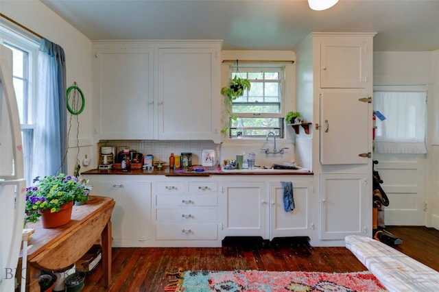 kitchen with white cabinets, dark wood-type flooring, decorative backsplash, and sink