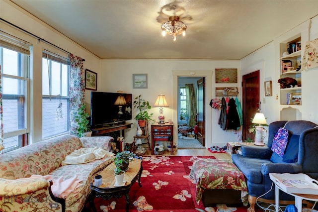 living room featuring built in shelves and hardwood / wood-style flooring