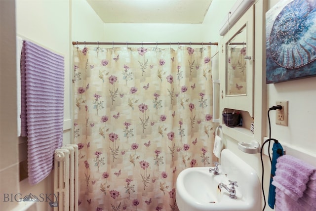 bathroom featuring radiator heating unit and sink