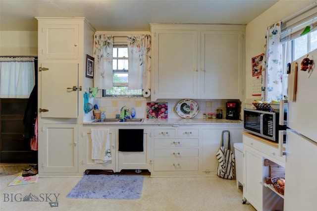325 N 3rd St, Livingston, MT 59047 - kitchen featuring stainless steel microwave, freestanding refrigerator, a sink, and tasteful backsplash