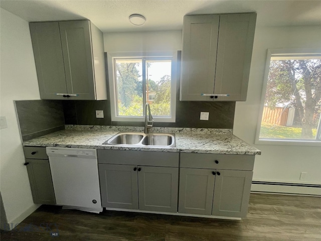 kitchen with dark hardwood / wood-style flooring, white dishwasher, sink, a baseboard heating unit, and light stone counters