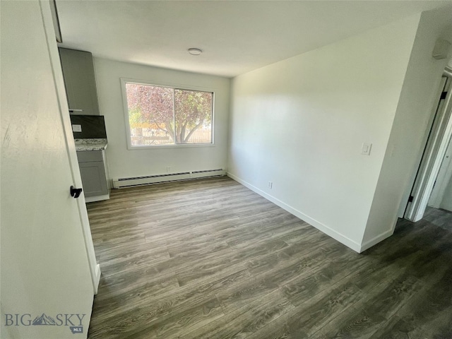 spare room with a baseboard heating unit and wood-type flooring