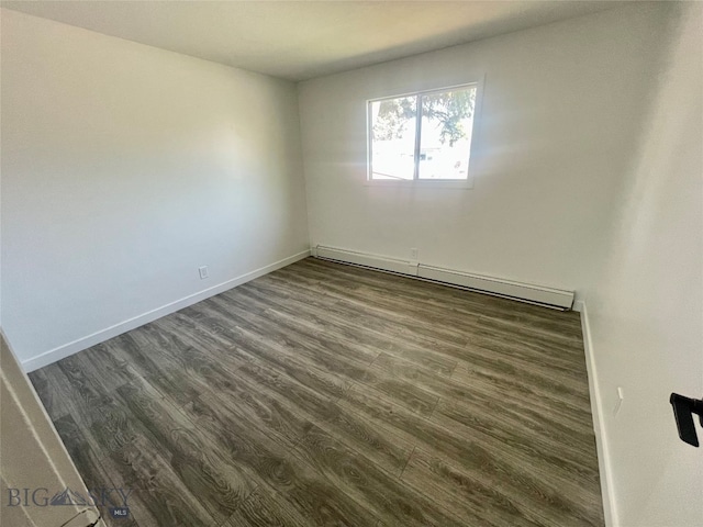 unfurnished room with a baseboard heating unit and hardwood / wood-style flooring