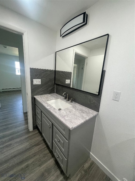 bathroom with vanity, baseboard heating, and wood-type flooring