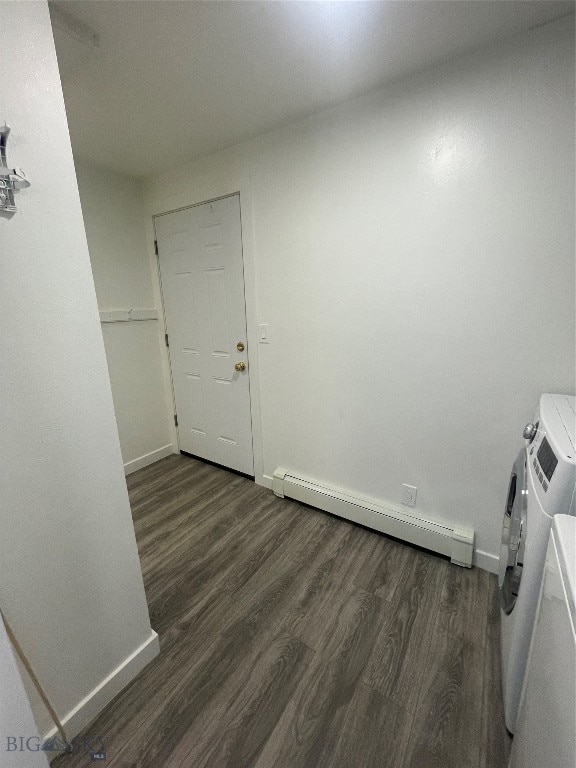 interior space featuring baseboard heating, hardwood / wood-style floors, and washing machine and clothes dryer