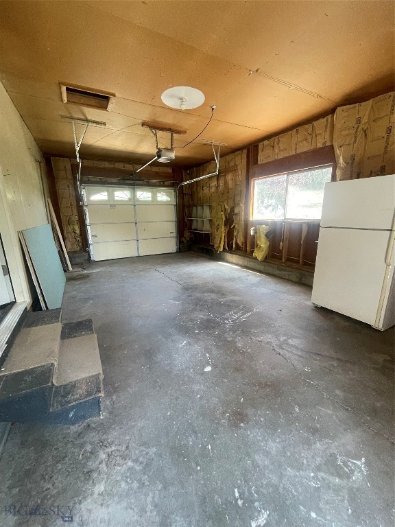 garage featuring a garage door opener and white fridge