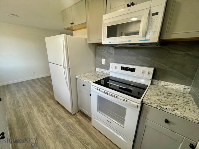 kitchen featuring white appliances, light hardwood / wood-style flooring, backsplash, and light stone counters