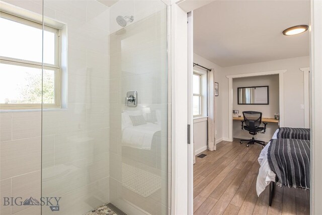 bathroom with wood-type flooring and an enclosed shower