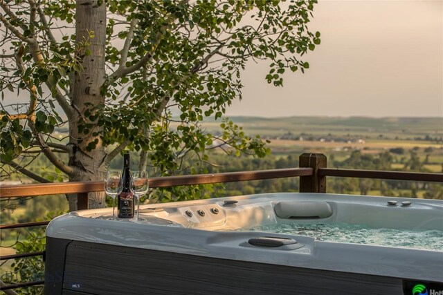 wooden deck with a rural view and a hot tub