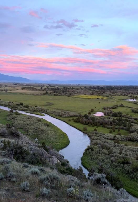 aerial view at dusk with a water view and a rural view