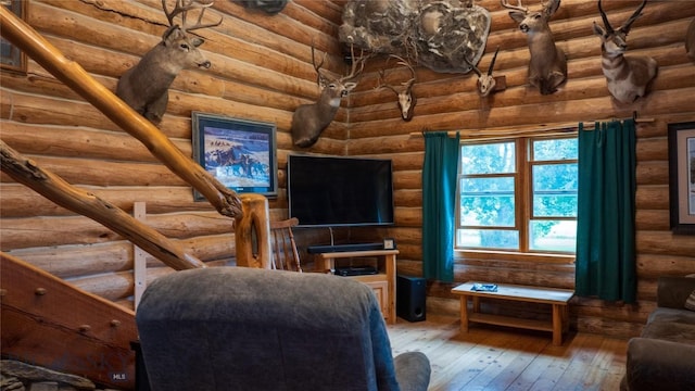 living room with wood-type flooring and rustic walls