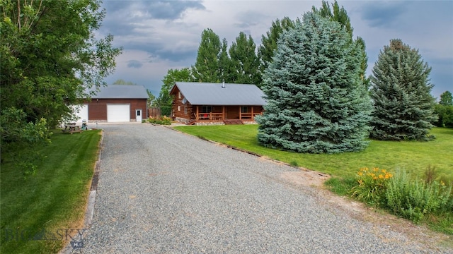 log-style house with an outbuilding, a garage, and a front yard