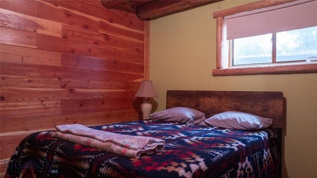 bedroom featuring beamed ceiling and wooden walls