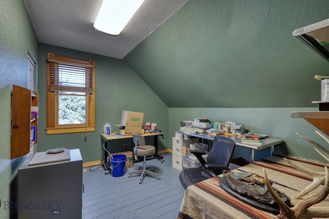 office area featuring lofted ceiling, hardwood / wood-style floors, and a textured ceiling