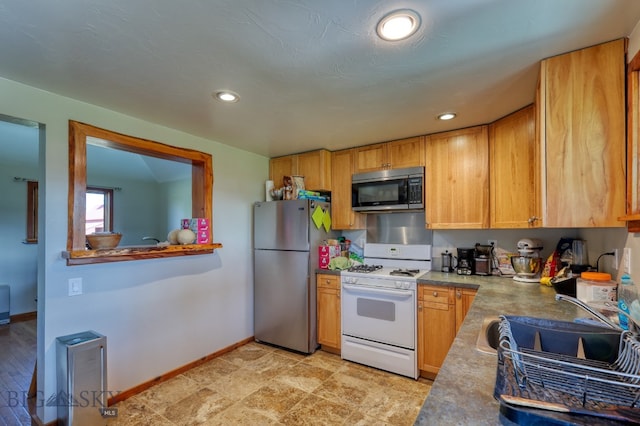 kitchen with sink, stainless steel appliances, and light tile patterned floors