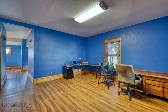 office space with light hardwood / wood-style flooring and a textured ceiling