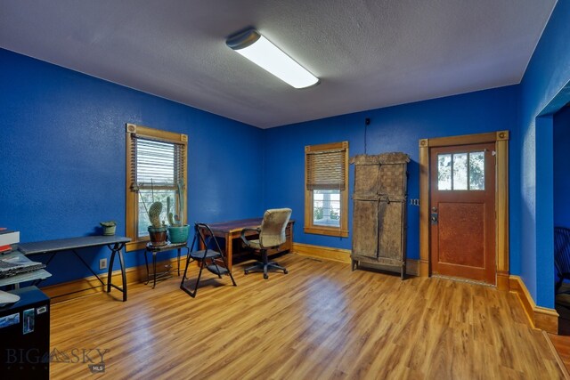 office featuring light wood-type flooring and a textured ceiling