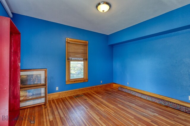 unfurnished room with hardwood / wood-style floors