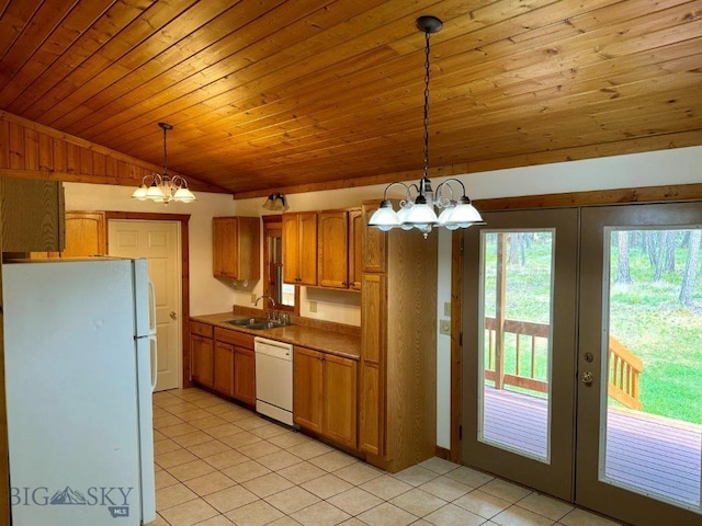 kitchen with white appliances, a notable chandelier, sink, light tile patterned flooring, and decorative light fixtures