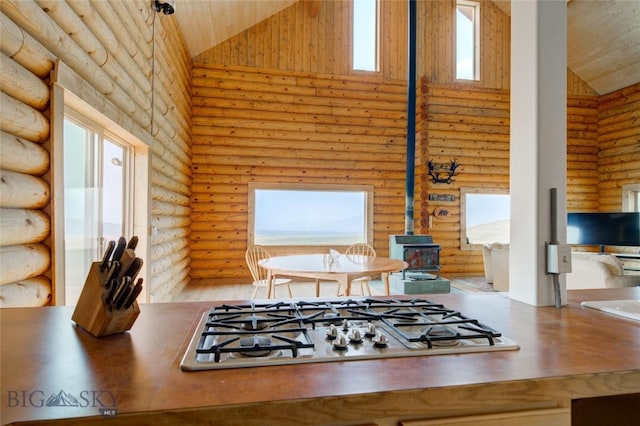 224 Slide Rock Rd, Cameron, MT 59720 - kitchen featuring a wood stove, rustic walls, high vaulted ceiling, wood ceiling, and stainless steel gas stovetop