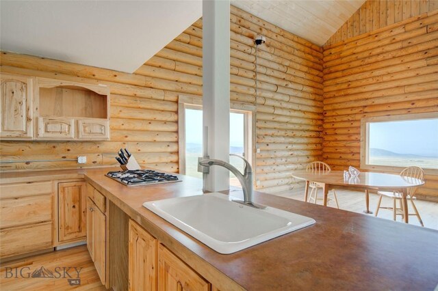 224 Slide Rock Rd, Cameron, MT 59720 - kitchen featuring stainless steel gas stovetop, light brown cabinets, rustic walls, plenty of natural light, and light wood-style floors