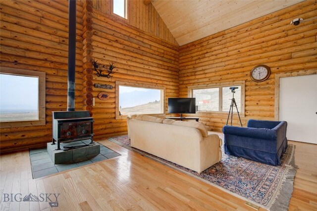 224 Slide Rock Rd, Cameron, MT 59720 - living room featuring high vaulted ceiling, a wood stove, plenty of natural light, rustic walls, and wood ceiling