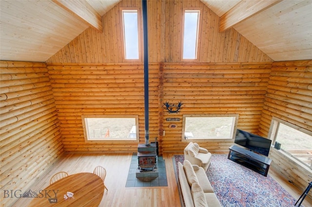 224 Slide Rock Rd, Cameron, MT 59720 - living area with high vaulted ceiling, a healthy amount of sunlight, log walls, and a wood stove