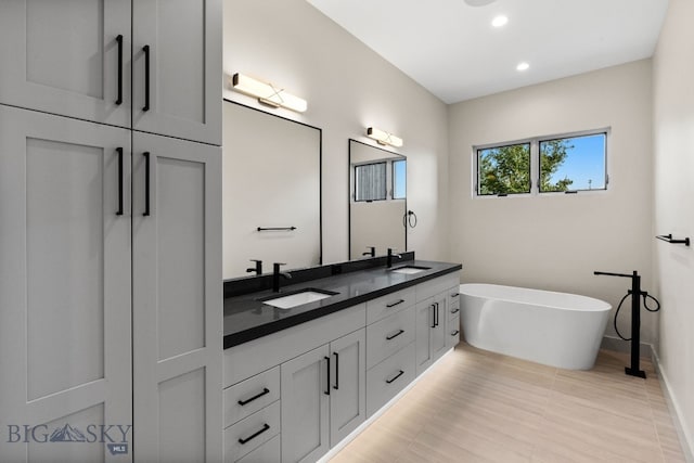 20 Bold Driver Ln, Bozeman, MT 59718 - bathroom with double vanity, a freestanding bath, recessed lighting, and baseboards