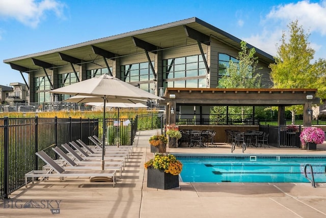 community pool with a patio area and fence
