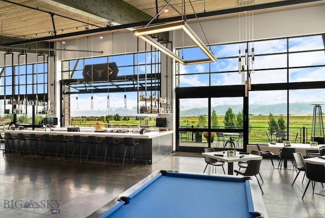 recreation room featuring a mountain view, billiards, plenty of natural light, and a towering ceiling