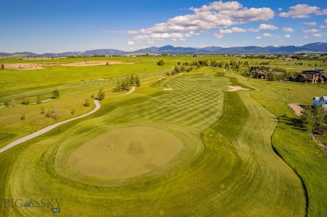 drone / aerial view with a mountain view and view of golf course