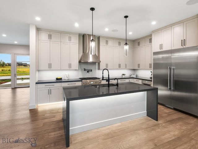 20 Bold Driver Ln, Bozeman, MT 59718 - kitchen with stainless steel built in fridge, wall chimney exhaust hood, dark countertops, a sink, and light wood-style floors