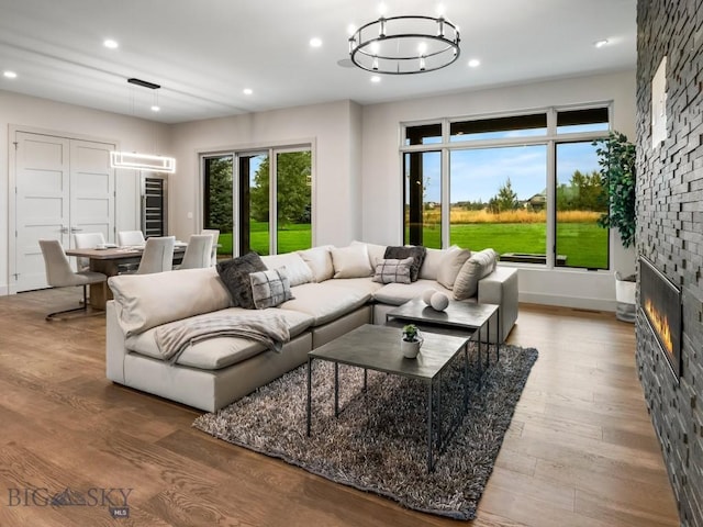 20 Bold Driver Ln, Bozeman, MT 59718 - living area with a stone fireplace, wood finished floors, recessed lighting, a chandelier, and baseboards